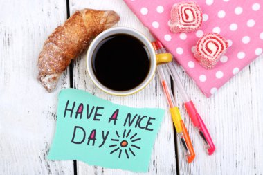 Kahve, taze kruvasan ve kağıt kartı