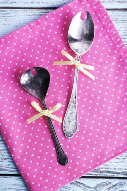 Pembe polka dot peçete ahşap arka plan üzerinde üzerinde metal kaşık