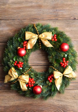 Ahşap arka plan üzerinde ökseotu ile dekoratif çelenk yapraklar Noel