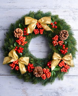 Ahşap arka plan üzerinde ökseotu ile dekoratif çelenk yapraklar Noel