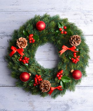 Ahşap arka plan üzerinde ökseotu ile dekoratif çelenk yapraklar Noel