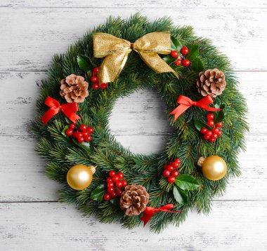 Ahşap arka plan üzerinde ökseotu ile dekoratif çelenk yapraklar Noel