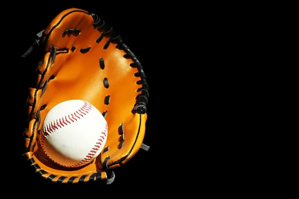 Bola de beisebol em luva no fundo preto — Fotografia de Stock
