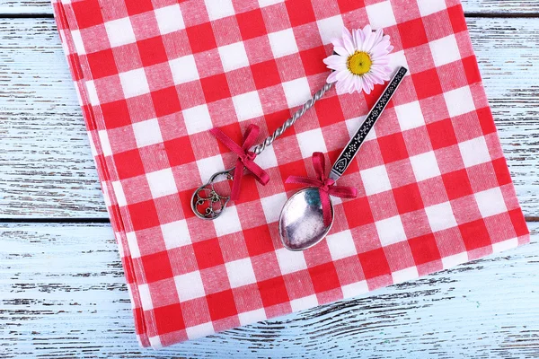 Metal spoons on checkered napkin — Stock Photo, Image