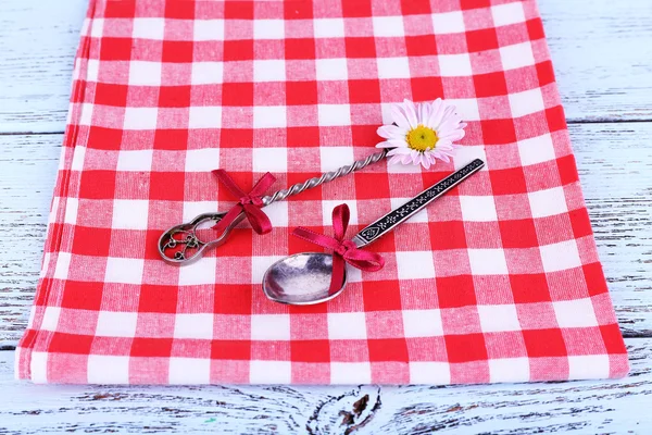 Metal spoons on checkered napkin — Stock Photo, Image