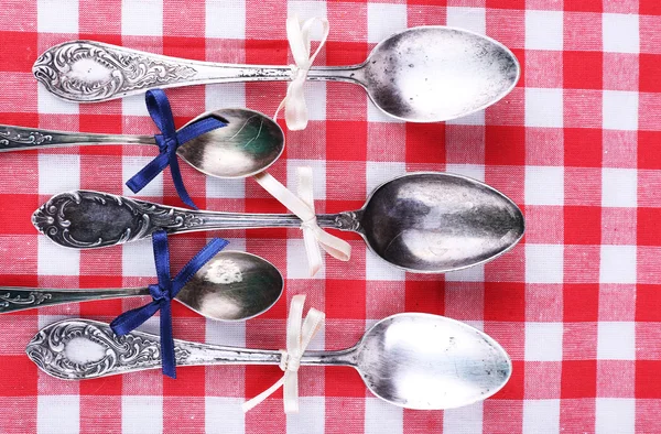 Metal spoons on checkered fabric background — Stock Photo, Image