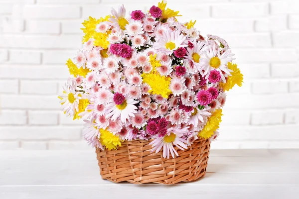 Beautiful flowers in wicker basket — Stock Photo, Image