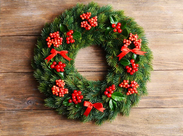 Kerst decoratieve krans met van maretak op houten achtergrond bladeren — Stockfoto