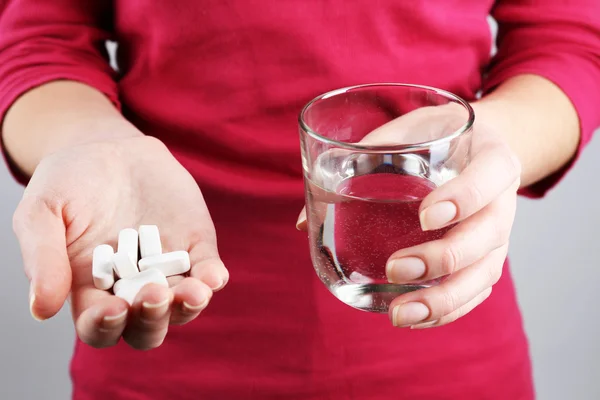 Händer med piller och vatten — Stockfoto