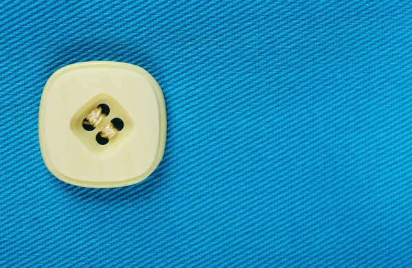 Button on blue cloth — Stock Photo, Image