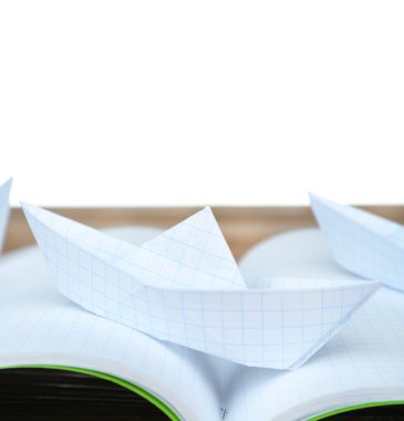 Beyaz arka plan üzerinde ahşap masa üstünde defter teknede origami