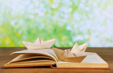 Origami tekneler ahşap masa, açık havada eski kitap üzerinde