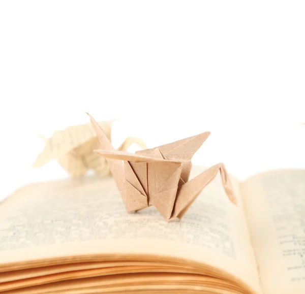 Origami cranes on old book, on white background — Stock Photo, Image