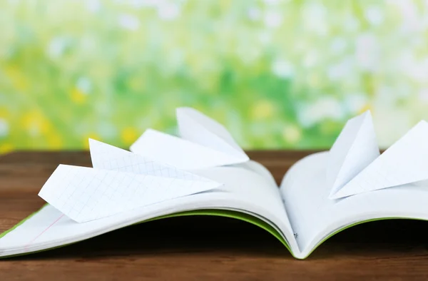 Aviões Origami no notebook, na mesa de madeira, ao ar livre — Fotografia de Stock