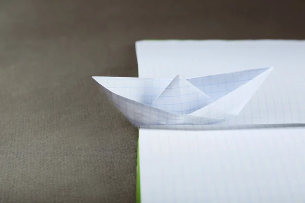 Origami båt på notebook, närbild — Stockfoto