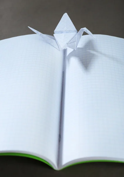 Origami tranor på anteckningsboken på grå bakgrund — Stockfoto