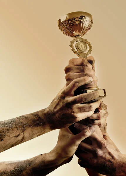 Gold cup in dirty hands — Stock Photo, Image