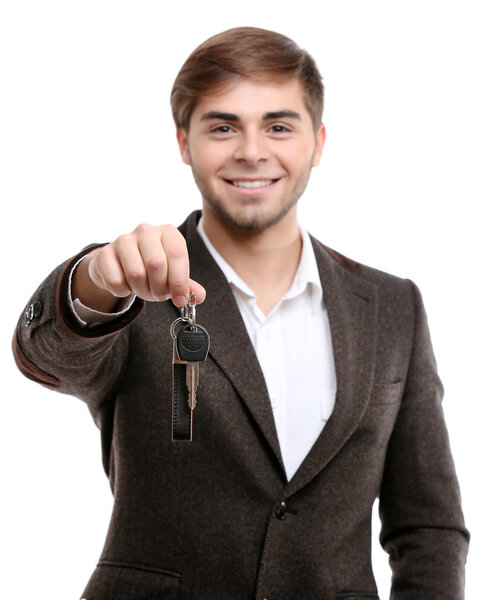Бизнесмен держит ключ от машины изолирован на белом
