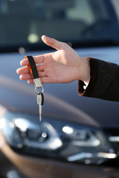 Businessman holding car key outdoors — Stock Photo, Image