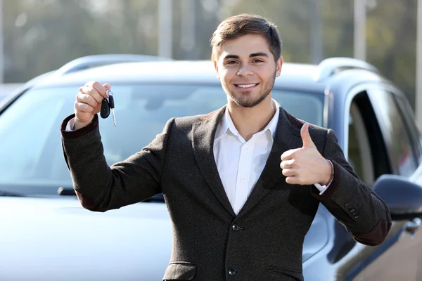 Businessman holding car key outdoors Royalty Free Stock Photos