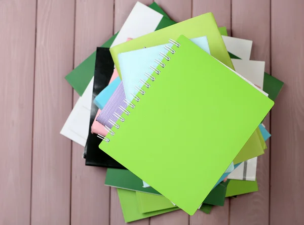 Notebook and pile of books — Stock Photo, Image