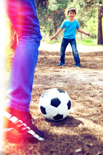 Happy dad and son playing football in the park — Stock Photo, Image