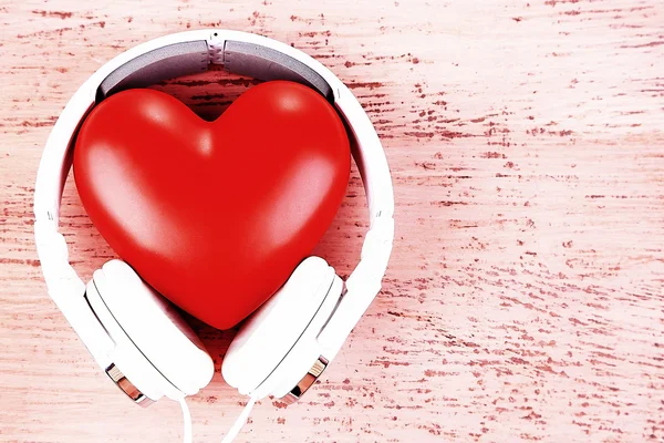 Auriculares y corazón sobre fondo de madera de color — Foto de Stock