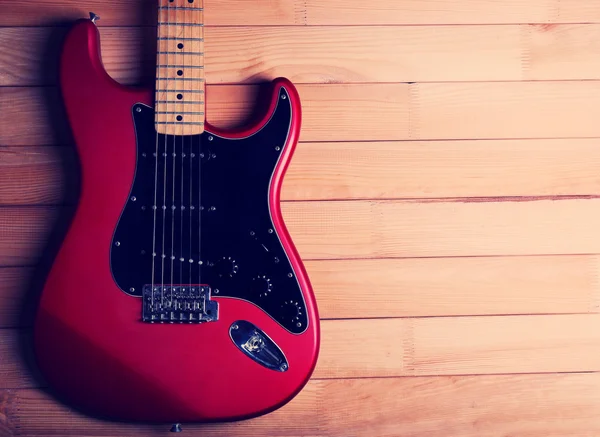 Red guitar on wooden background — Stock Photo, Image