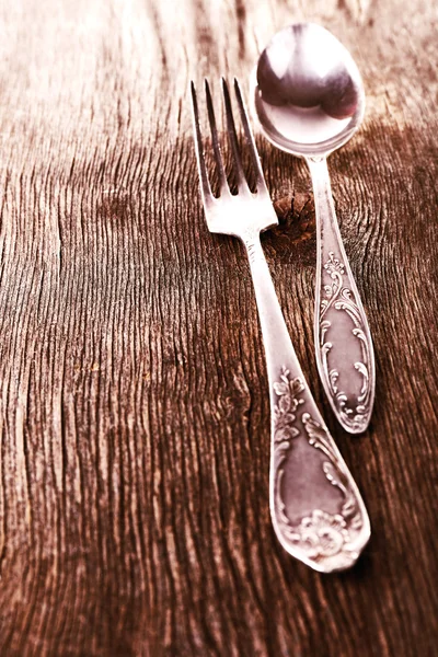 Vecchio cucchiaio di metallo e forchetta su sfondo di legno — Foto Stock