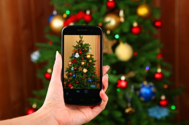 El alarak fotoğraf Noel ağacının yanında smartphone