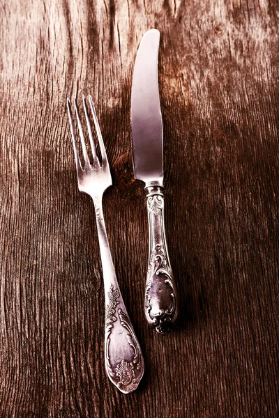 Old metal knife and fork on wooden background — Stock Photo, Image