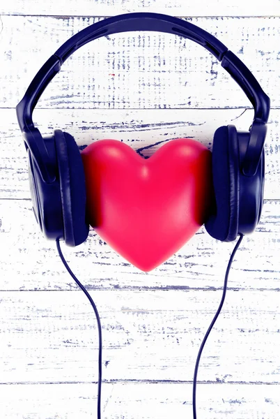 Headphones and heart on wooden background — Stock Photo, Image
