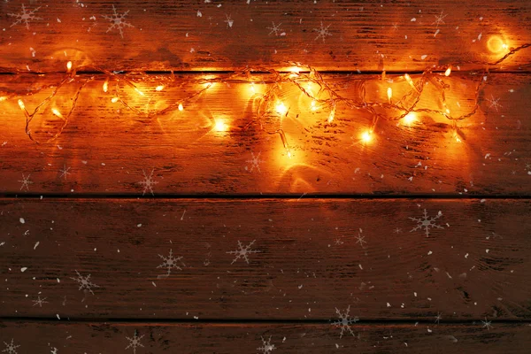 Luzes de Natal no fundo de madeira — Fotografia de Stock