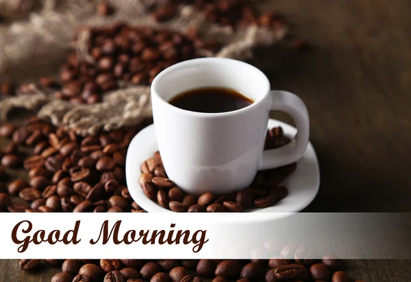 Cup of coffee and coffee beans on wooden background — Stock Photo, Image