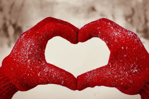 Las manos de mujer en guantes rojos sobre fondo natural de invierno — Foto de Stock