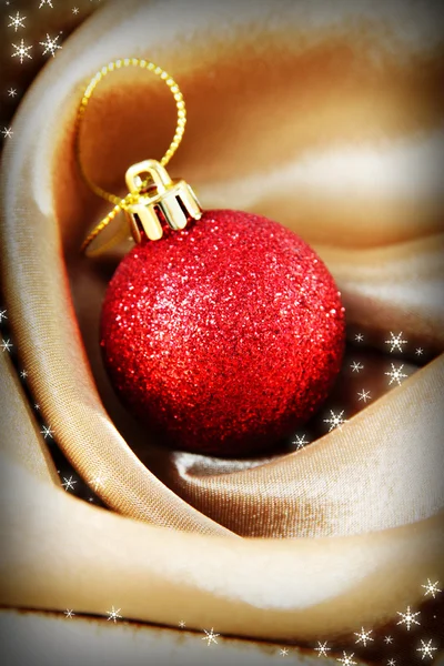 Beautiful Christmas ball on golden satin cloth — Stock Photo, Image