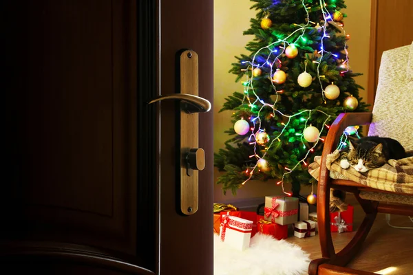 Porta aberta com árvore de Natal decorada no quarto — Fotografia de Stock