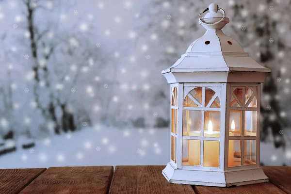 Lantern on wooden table on winter background — Stock Photo, Image