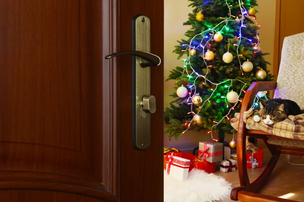 Puerta abierta con árbol de Navidad decorado en la habitación — Foto de Stock