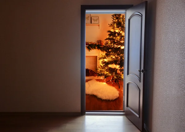 Porta aberta com árvore de Natal decorada no quarto — Fotografia de Stock