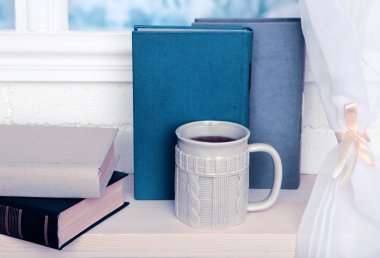 Eski kitaplar ve pencere üzerinde kahve