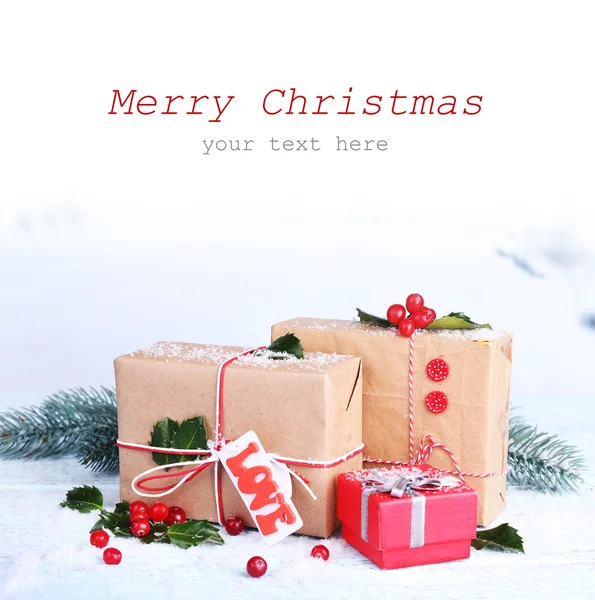 Hermosos regalos de Navidad con acebo europeo (Ilex aquifolium) sobre fondo claro —  Fotos de Stock