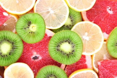 Olgun dilim limon, kivi ve greyfurt yakın çekim arka plan