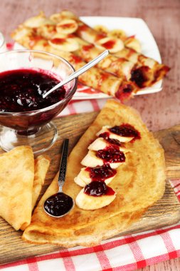 Berry reçel ve ahşap arka plan üzerinde ahşap tahta üzerinde muz ile lezzetli gözleme