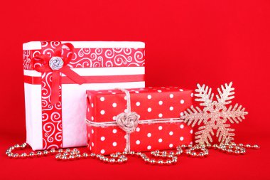 Güzel parlak hediyeler ve kırmızı bir arka plan üzerinde Noel dekorasyon