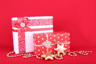 Güzel parlak hediyeler ve kırmızı bir arka plan üzerinde Noel dekorasyon