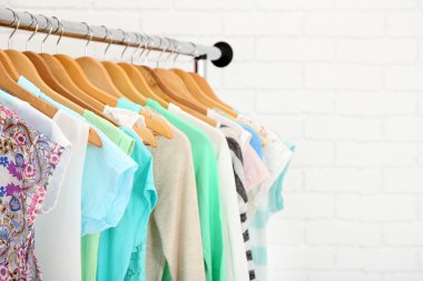 Askılarda farklı giysiler. Kapatın.