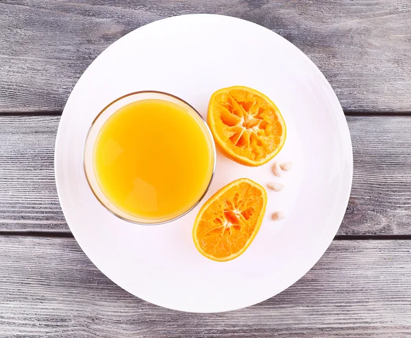 Glas juice och mogen söt tangerine på träbord — Stockfoto