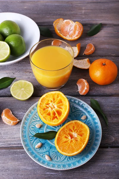 Saft und Zitrusfrüchte auf dem Tisch — Stockfoto