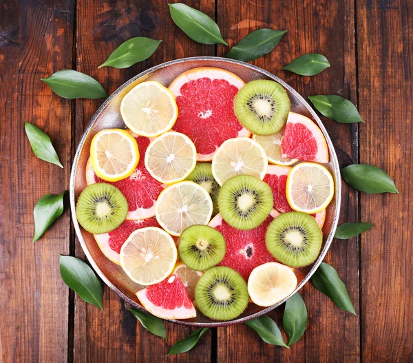 Zralé plátky citronu, kiwi a grapefruity na zásobník na dřevěné pozadí — Stock fotografie